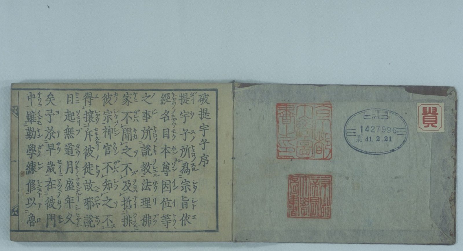 Opening of a woodblock-printed Japanese book: a page of Chinese text with reading marks facing an inside cover stamped with red seals