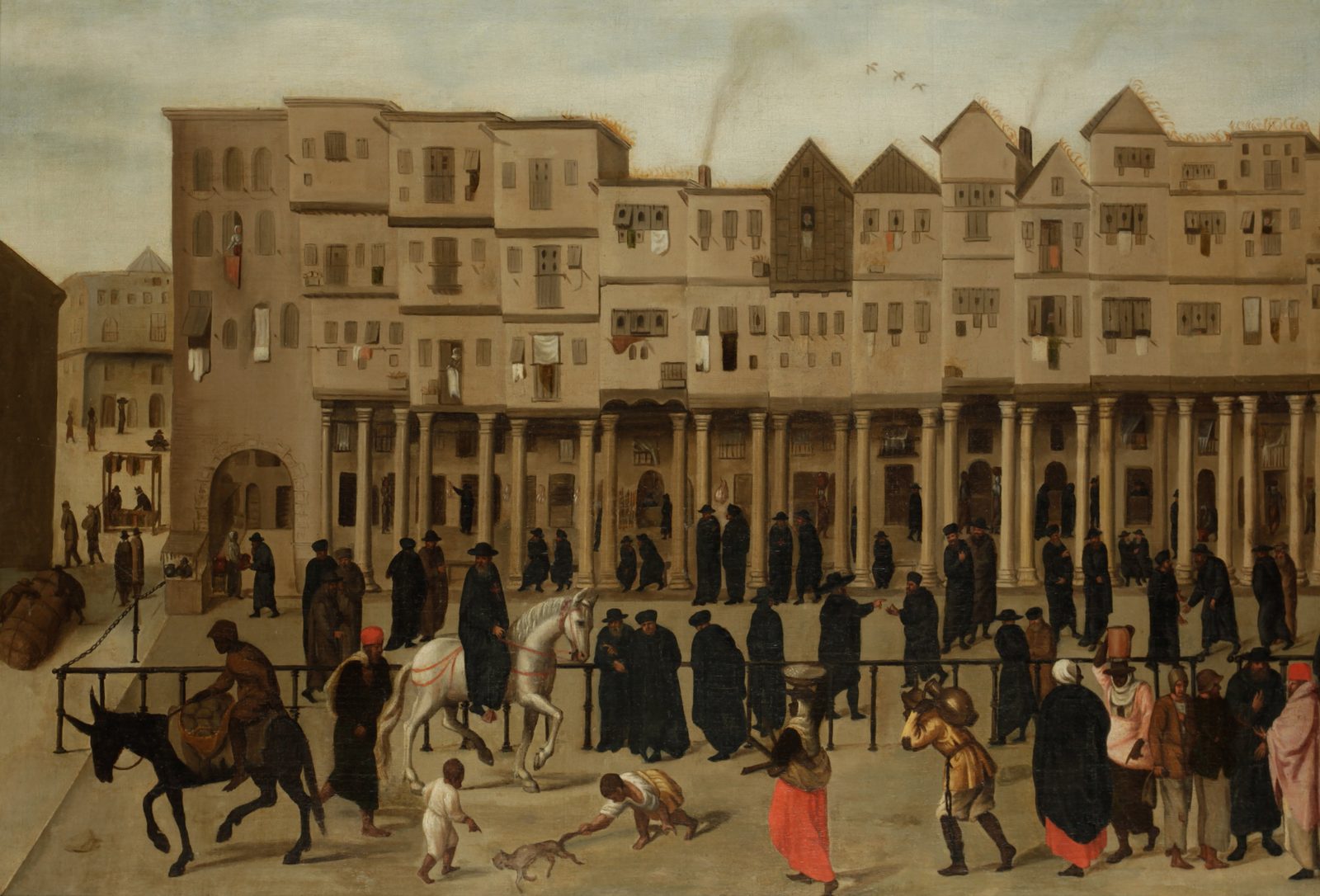 The Rua Nova dos Mercadores in 16th-century Lisbon, in a Flemish painting: merchants in black under the arcade, laundry at the windows, porters, a white horse