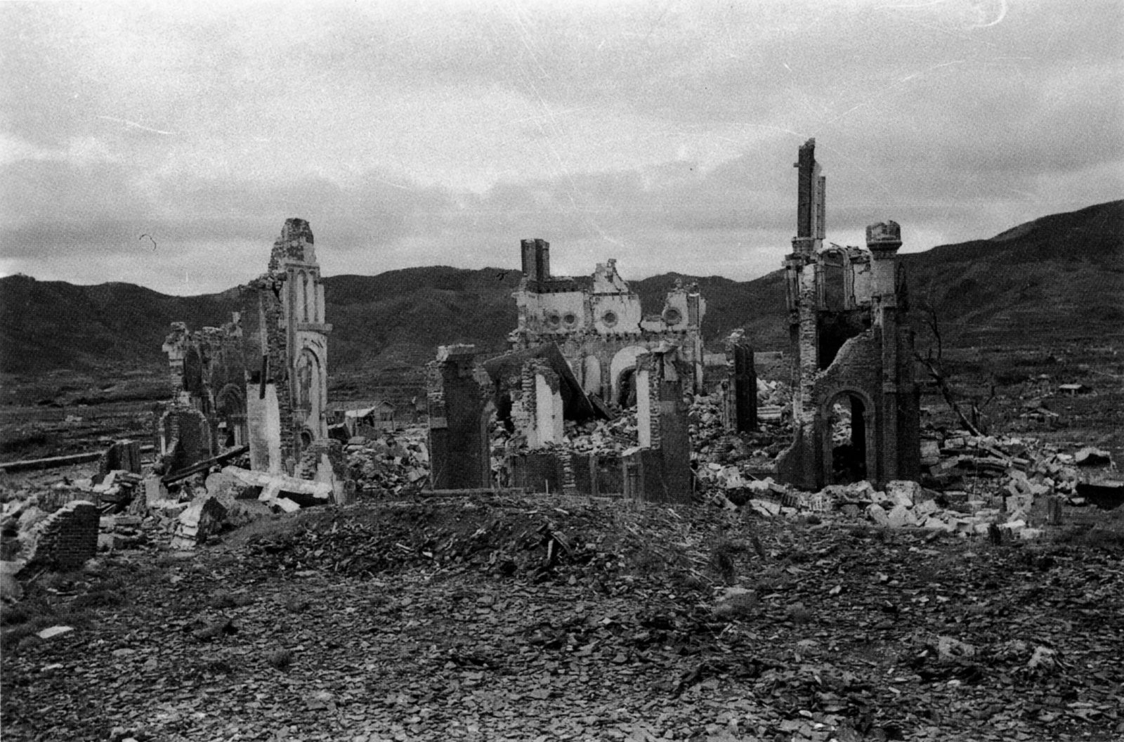 The ruined brick walls and rubble of Urakami Cathedral on its hillside, photographed in the spring of 1946.